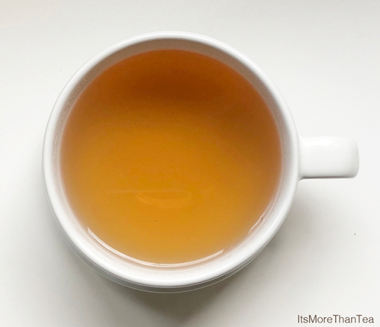 yellow tea in white cup